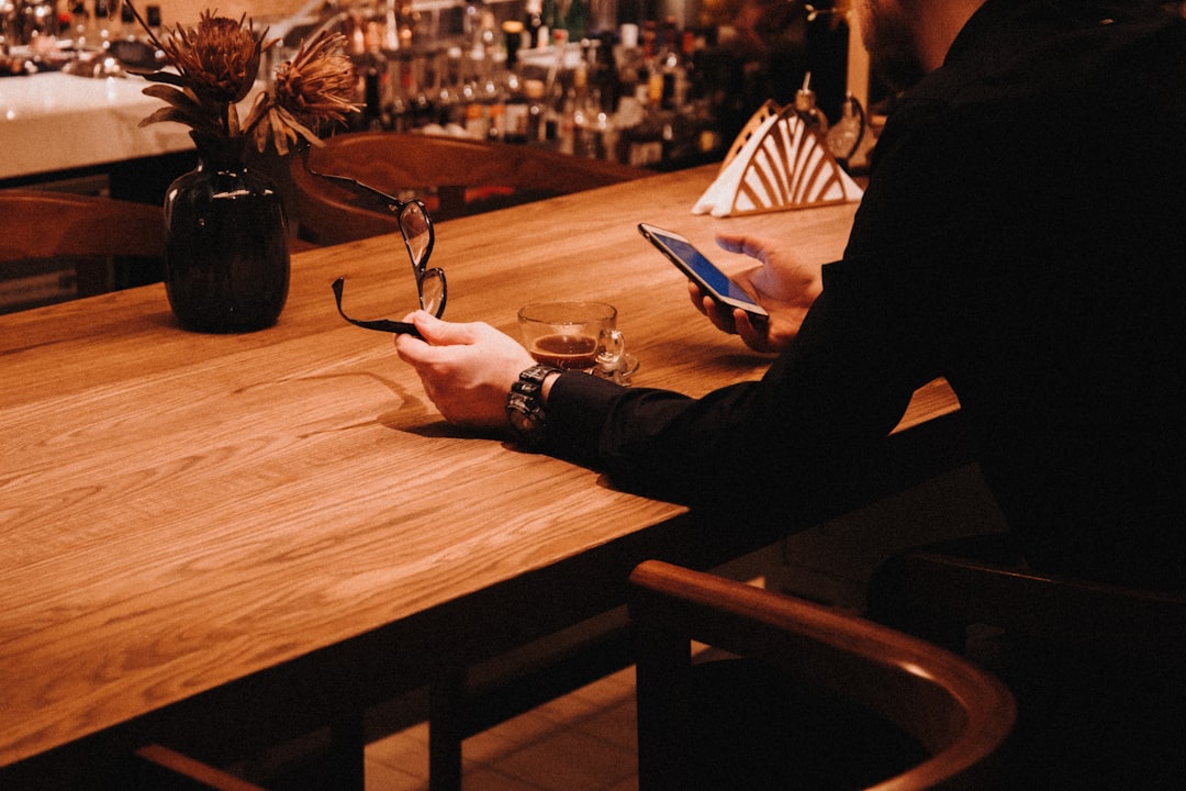 A man and a woman shaking hands over a table with a contract document.
