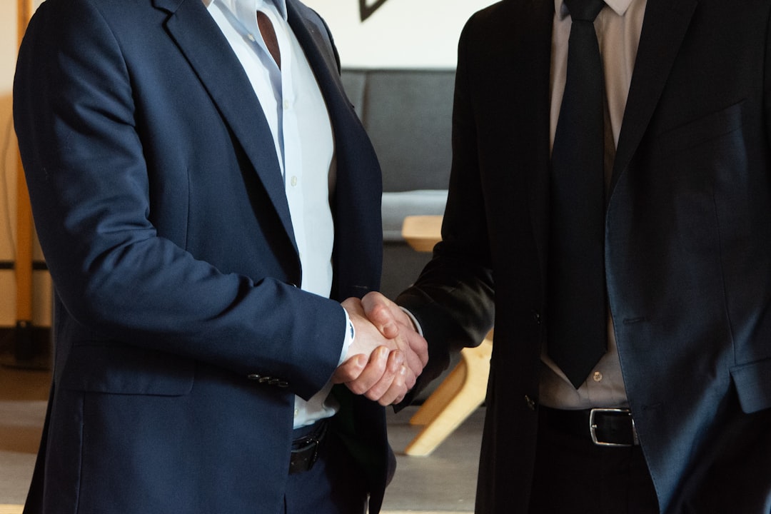 A handshake between a landlord and tenant over a signed rental agreement.