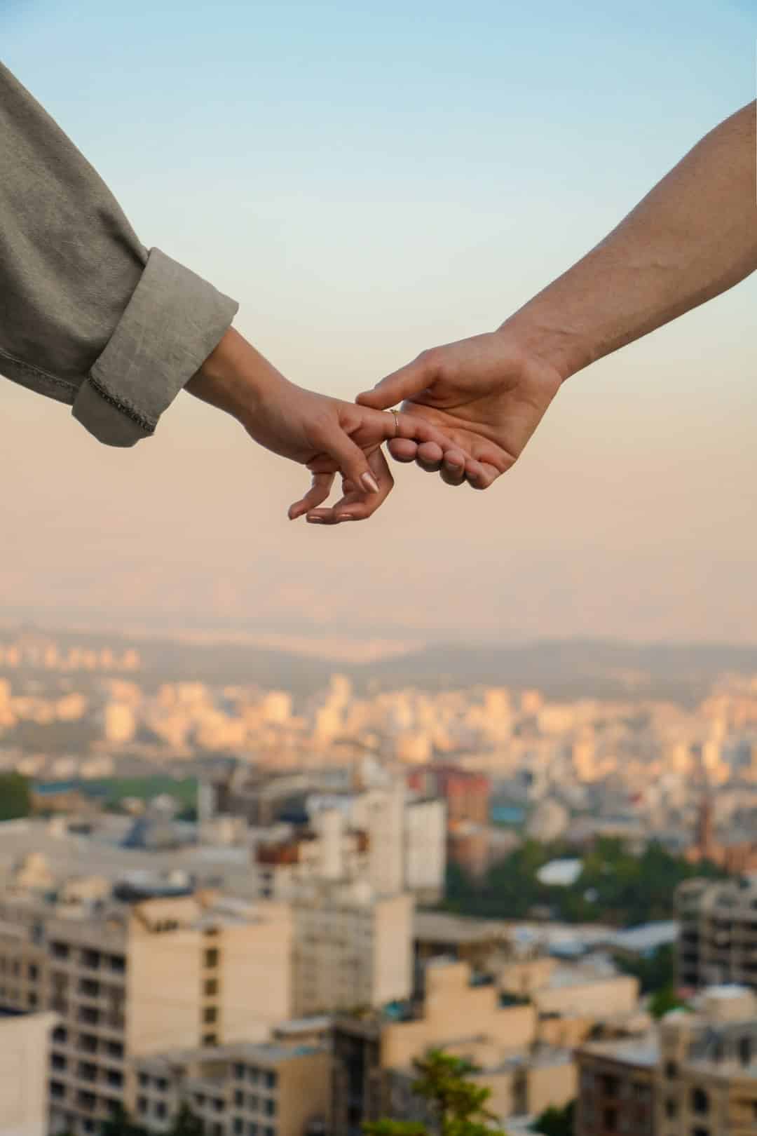 A handshake between a landlord and a tenant over a rental agreement on a table.